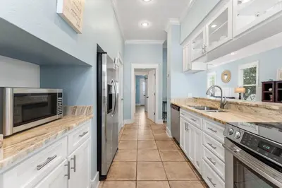 a kitchen with white cabinets and a microwave at Aquanut Beach House 30A in Inlet Beach