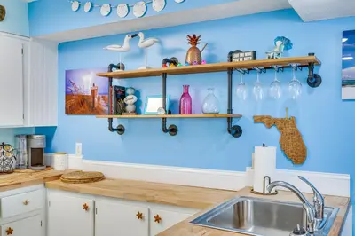 a kitchen with a sink and shelves on the wall at PCB Apt with Balcony and Gulf Views Walk to Beach in Panama City Beach