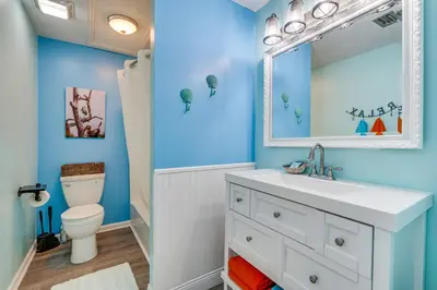 a blue bathroom with a sink and a toilet at PCB Apt with Balcony and Gulf Views Walk to Beach in Panama City Beach