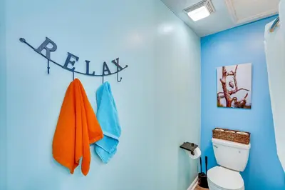 a bathroom with a toilet and a blue wall at PCB Apt with Balcony and Gulf Views Walk to Beach in Panama City Beach