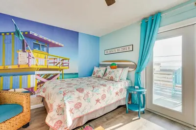 a bedroom with a bed and a roller coaster at PCB Apt with Balcony and Gulf Views Walk to Beach in Panama City Beach