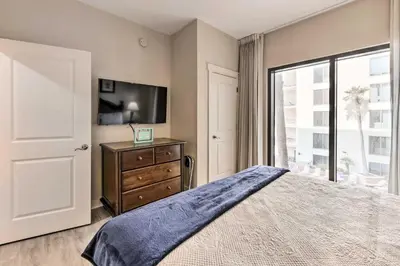 a bedroom with a bed and a tv and a window at Scenic PCB Condo with Stunning Sunsets and Beach View! in Panama City Beach