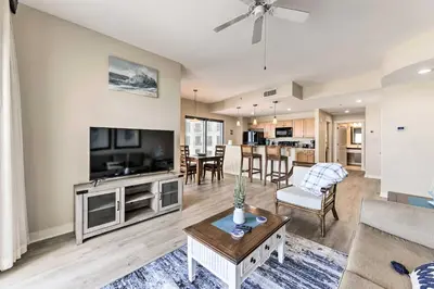 a living room with a couch and a tv at Scenic PCB Condo with Stunning Sunsets and Beach View! in Panama City Beach