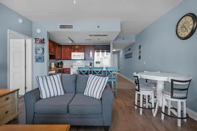 a living room and kitchen with a couch and a table at Laketown Wharf 1626 in Panama City Beach
