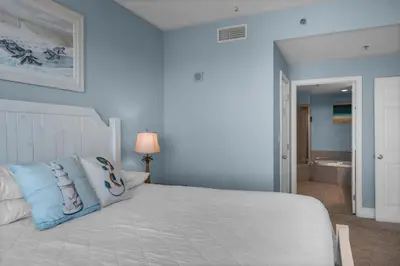 a bedroom with a large bed with blue walls at Laketown Wharf 1626 in Panama City Beach