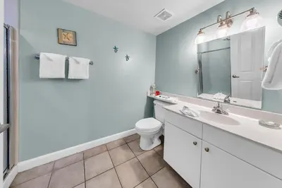 a white bathroom with a sink and a toilet at Shores of Panama 830 in Panama City Beach