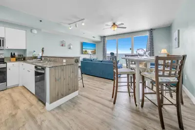 a kitchen and living room with a table and chairs at Shores of Panama 830 in Panama City Beach