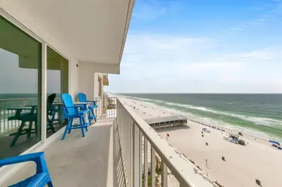 a balcony with blue chairs and a view of the beach at Shores of Panama 830 in Panama City Beach