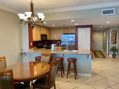 a kitchen and dining room with a table and chairs at Grandview East 404 in Panama City Beach
