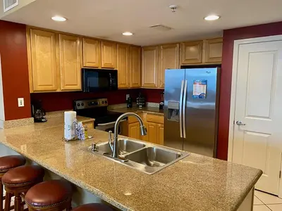 a kitchen with a sink and a refrigerator at Grandview East 404 in Panama City Beach