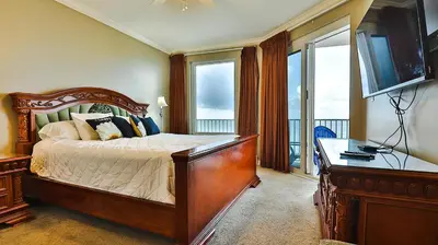 a bedroom with a bed with a dresser and a television at Grandview East 404 in Panama City Beach