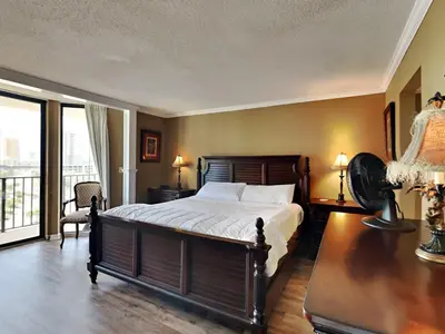 a bedroom with a large bed and a balcony at Edgewater Tower I 912 in Panama City Beach