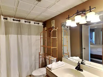 a bathroom with a sink and a toilet and a mirror at Edgewater Tower I 912 in Panama City Beach