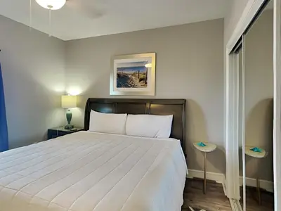 a bedroom with a large white bed with two tables at Majestic Beach Towers I #1111 in Panama City Beach