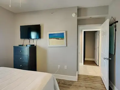 a bedroom with a bed and a tv on a wall at Majestic Beach Towers I #1111 in Panama City Beach