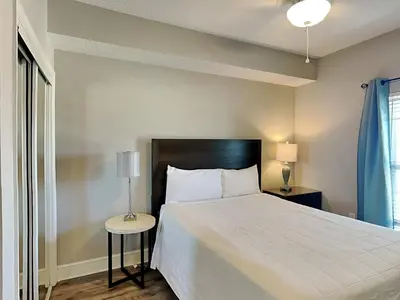 a bedroom with a large white bed and a window at Majestic Beach Towers I #1111 in Panama City Beach