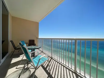 a balcony with a table and chairs and the ocean at Majestic Beach Towers I #2210 in Panama City Beach