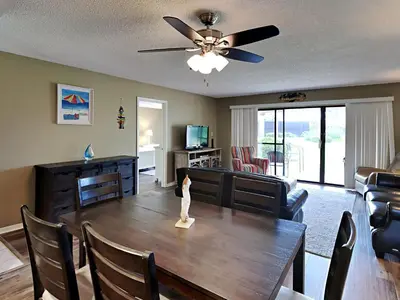a living room with a dining room table with a ceiling fan at Edgewater Villa #2605 in Panama City Beach