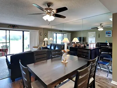 a dining room and living room with a table and chairs at Edgewater Villa #2605 in Panama City Beach