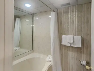 a bathroom with a tub and a shower with a mirror at Edgewater Tower 1 Unit 101 in Panama City Beach