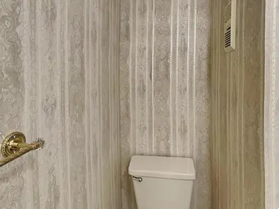 a bathroom with a toilet and a wall with wallpaper at Edgewater Tower 1 Unit 101 in Panama City Beach