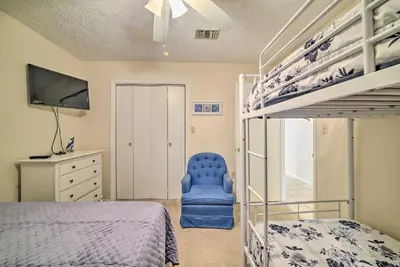 a bedroom with a bunk bed and a blue chair at 2 Mi to Beach! Bayside PCB Escape with Pool Access in Panama City Beach
