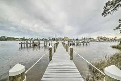 a dock on a lake with a city in the background at 2 Mi to Beach! Bayside PCB Escape with Pool Access in Panama City Beach