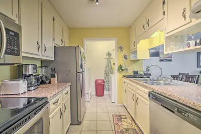 a kitchen with white cabinets and a stainless steel refrigerator at 2 Mi to Beach! Bayside PCB Escape with Pool Access in Panama City Beach