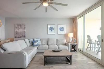 a living room with a couch and a ceiling fan at Totally Beach'n at 1605 Aqua in Panama City Beach