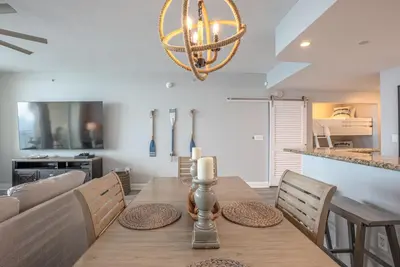 a dining room with a table and a chandelier at Totally Beach'n at 1605 Aqua in Panama City Beach