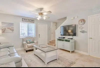 a living room with a couch and a tv at Desirable Pet Friendly Resort, 3 minute walk to the Beach, Beachside Pool & Restaurant Message for Snow Bird Rates in Panama City Beach