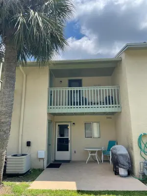 a house with a balcony and a table and chairs at Desirable Pet Friendly Resort, 3 minute walk to the Beach, Beachside Pool & Restaurant Message for Snow Bird Rates in Panama City Beach