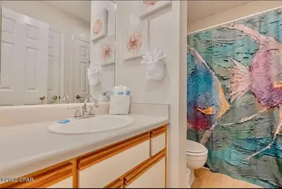 a bathroom with a sink and a painting on the wall at Desirable Pet Friendly Resort, 3 minute walk to the Beach, Beachside Pool & Restaurant Message for Snow Bird Rates in Panama City Beach