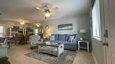a living room with a blue couch and a table at Desirable Pet Friendly Resort, 3 minute walk to the Beach, Beachside Pool & Restaurant Message for Snow Bird Rates in Panama City Beach