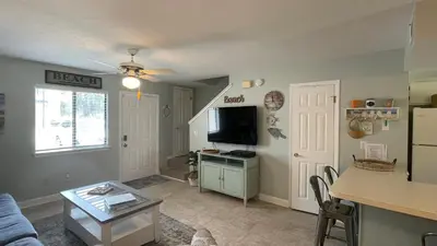 a living room with a couch and a table at Desirable Pet Friendly Resort, 3 minute walk to the Beach, Beachside Pool & Restaurant Message for Snow Bird Rates in Panama City Beach