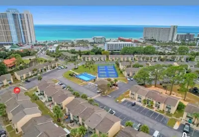 an aerial view of a resort with a pool and the beach at Desirable Pet Friendly Resort, 3 minute walk to the Beach, Beachside Pool & Restaurant Message for Snow Bird Rates in Panama City Beach