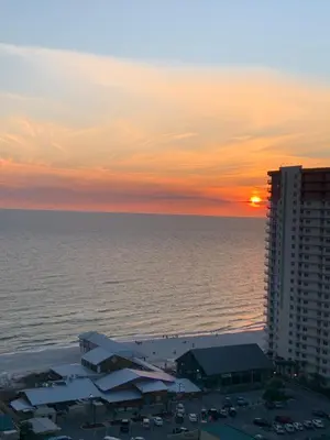a sunset over the ocean and a building at 1717 Laketown Wharf 1 King Bedroom, 2 Bath in Panama City Beach