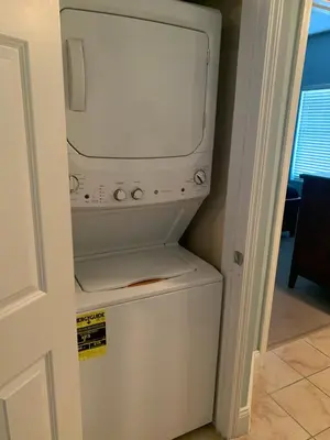 a white refrigerator with a washer and dryer in a room at 1717 Laketown Wharf 1 King Bedroom, 2 Bath in Panama City Beach