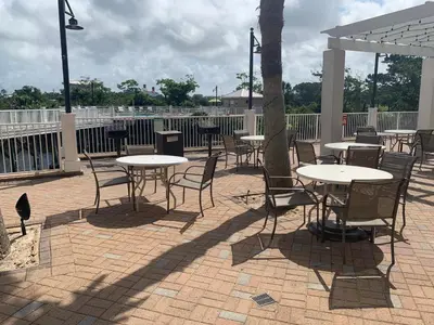 a patio with tables and chairs and a tree at 1717 Laketown Wharf 1 King Bedroom, 2 Bath in Panama City Beach