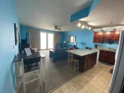 an open kitchen and living room with blue walls at 1717 Laketown Wharf 1 King Bedroom, 2 Bath in Panama City Beach