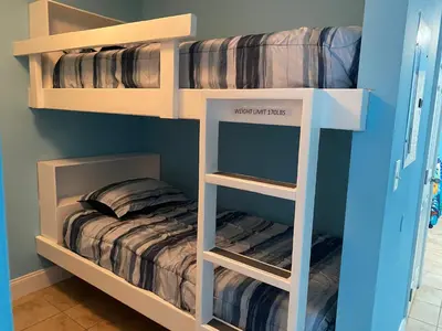 two bunk beds in a room with a bed at 1717 Laketown Wharf 1 King Bedroom, 2 Bath in Panama City Beach