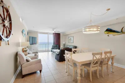 a dining room and living room with a table and chairs at Tidewater 302 in Panama City Beach