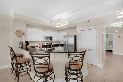 a kitchen with a table and chairs and a counter at Tidewater 302 in Panama City Beach