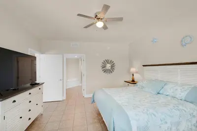 a bedroom with a bed and a ceiling fan at Tidewater 302 in Panama City Beach