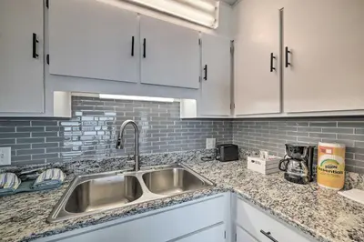 a kitchen with a sink and white cabinets at Oceanfront Panama City Beach Condo with Pool Access in Panama City Beach