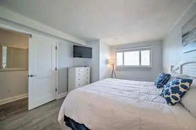 a bedroom with a white bed and a television at Oceanfront Panama City Beach Condo with Pool Access in Panama City Beach