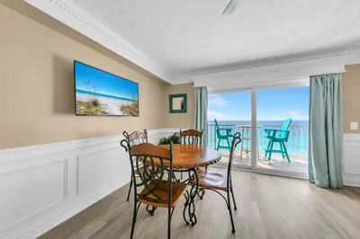 a dining room with a table and chairs and a balcony at The Summit 1323 in Panama City Beach
