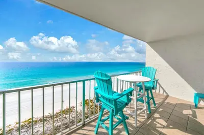 a balcony with chairs and a table and the ocean at The Summit 1323 in Panama City Beach