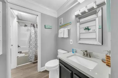 a bathroom with a sink and a toilet and a mirror at The Summit 1323 in Panama City Beach