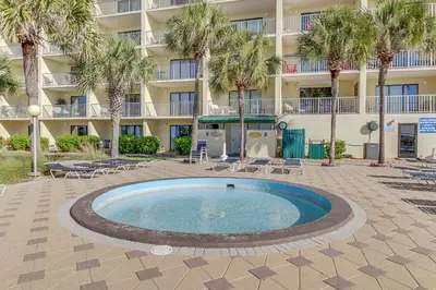 a swimming pool in front of a building with palm trees at The Summit 1323 in Panama City Beach